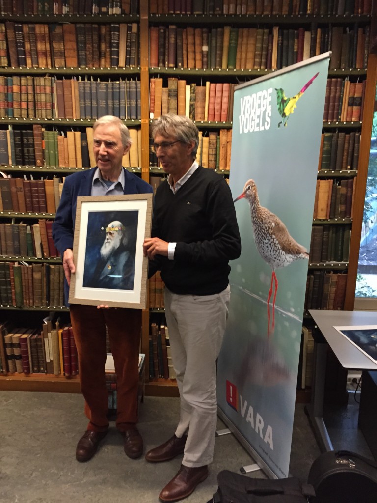 Links Louis Schoonhoven (hoofdauteur) en rechts Rolf Roos (boekbezorger) uitreiking Jan Wolkersprijs 18 oktober 2015 in de Artis Bibliotheek; beeld Darwin met bloemen- en beestenkrans van de hand van Siegfrid Woldhek